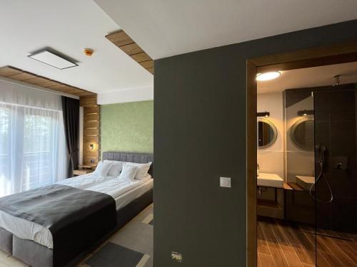 a bedroom with a large bed and a bathroom at Pensiunea Senin in Sovata