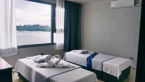 two beds in a room with a large window at Cube9 Resort & Spa 큐브9 리조트 & 스파 in Agus