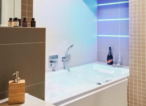 a bath tub with a faucet in a bathroom at IMPERIAL Apartments in Karlovy Vary