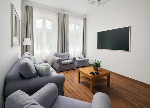 a living room with a couch and a tv at IMPERIAL Apartments in Karlovy Vary