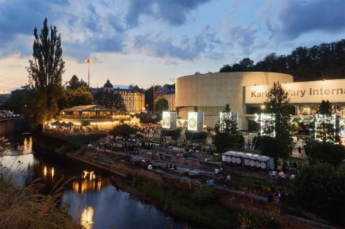 a lit up city with a building and a river at IMPERIAL Apartments in Karlovy Vary