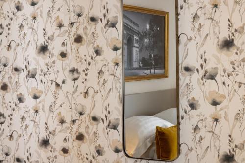 a mirror in a room with a floral wallpaper at Villa des Ambassadeurs in Paris