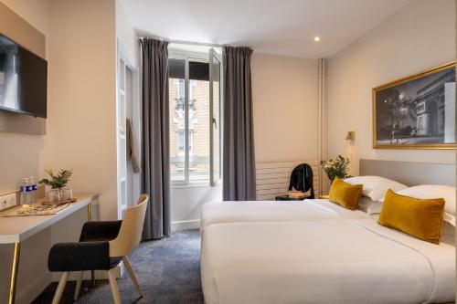 a hotel room with two beds and a desk at Villa des Ambassadeurs in Paris