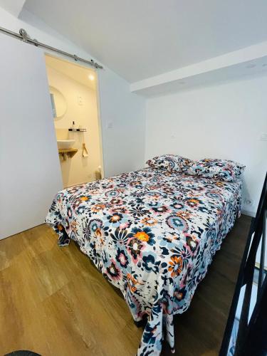 une chambre avec un lit avec un couvre-lit fleuri dans l'établissement Superbe Loft 2 niveaux Comédie Gare, à Montpellier