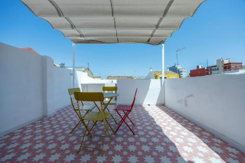 a room with chairs and a table on a balcony at Artisan Haven: El Cabanyal Oasis in Valencia