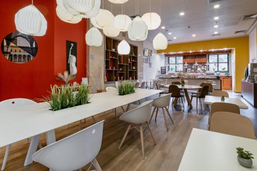 a restaurant with white tables and chairs and lights at B&B Hotel Cremona in Cremona
