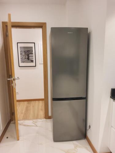 a stainless steel refrigerator in a room with a hallway at My Home in Braga