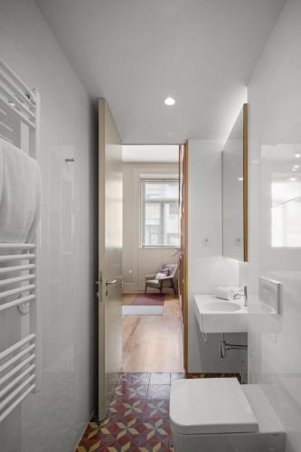 a bathroom with a toilet and a sink at Baumhaus Serviced Living - Art & Design Apartments in Porto