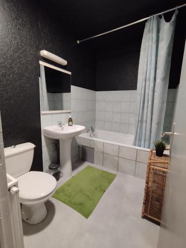 une salle de bain avec un lavabo, des toilettes et une baignoire dans l'établissement Gites Le Roosevelt - Côte 204, à Château-Thierry