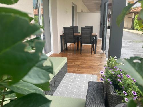 a porch with a table and chairs and plants at DESIGN LODGE - Apartment with Terrace in Tyrol, presendet by AlpenLuxus in Kramsach