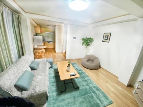 東京にあるHotaku HOTEL Akihabaraのソファとテーブルのあるリビングルーム