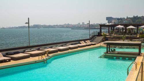 a swimming pool with lounge chairs and the water at Room Oportunity Guia Cascais in Cascais