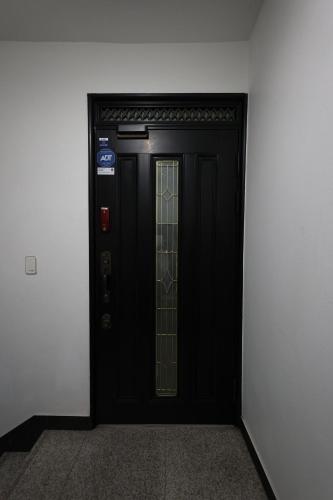 una porta nera con una finestra di vetro in un edificio di Free pick-up, 4 Beds, near Gangnam, Hongdae, Subway 8 mins, Spacious a Seul