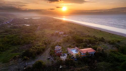 an aerial view of a house on the beach at sunset at Hosteria Mar de Plata in Cabuyal