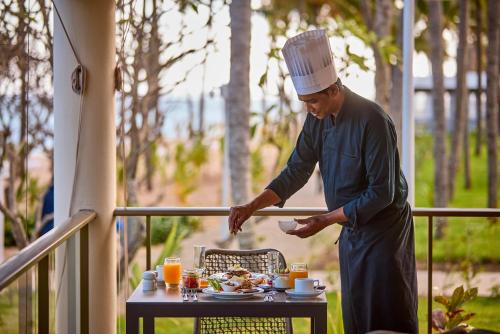 a man in a chefs hat preparing food on a table at Riu Palace Mauritius - All Inclusive - Adults Only in Le Morne