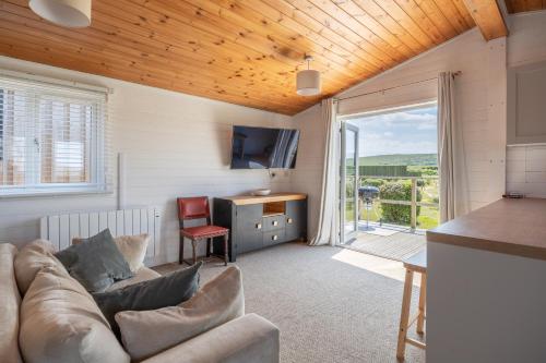 a living room with a couch and a television at West Chalet At Tapnell Farm in Yarmouth
