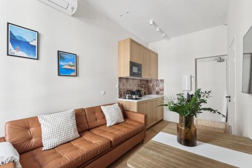 un salon avec un canapé marron et une cuisine dans l'établissement Rivages Saint Ferréol, à Marseille