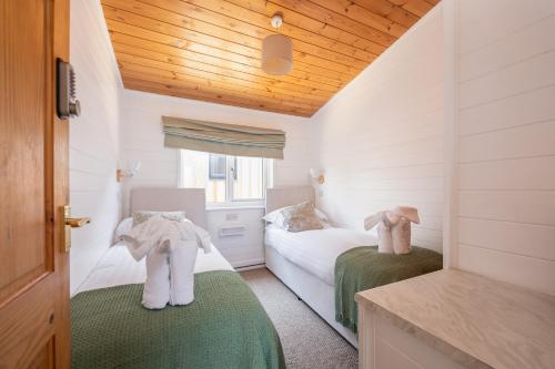 a bedroom with two beds with towels on them at West Chalet At Tapnell Farm in Yarmouth