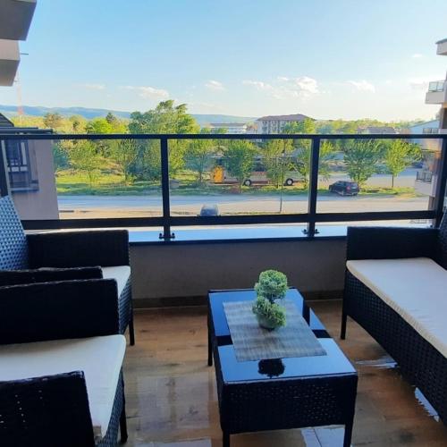 a living room with couches and a table and a large window at Apartman Sara S in Veliko Gradište