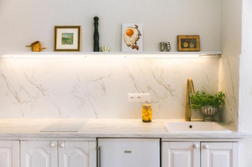 a kitchen with white marble countertops and a sink at Vila Šilelis in Palanga