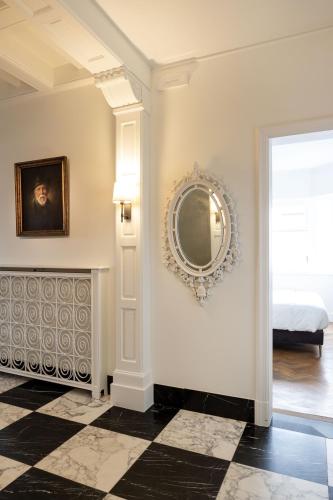 a room with a mirror on the wall and a bed at Tuss in Kortrijk