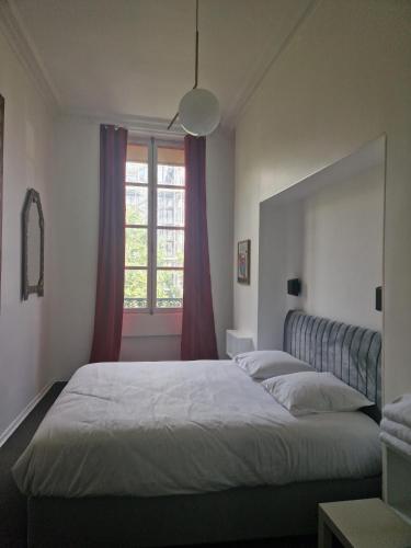 une chambre avec un grand lit et une fenêtre dans l'établissement Le Circus, à Paris