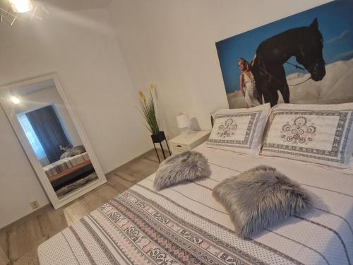 a bedroom with a bed with two pillows and a horse mural at Apartament de lux in Craiova