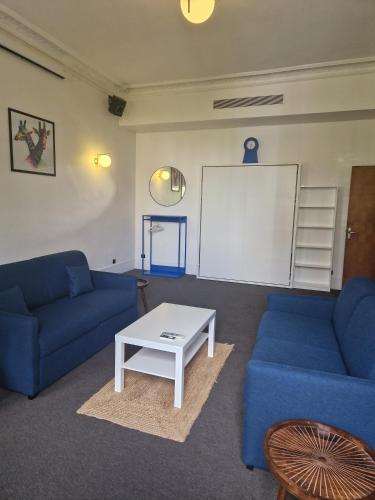 - un salon avec deux canapés bleus et une table blanche dans l'établissement Le Circus, à Paris