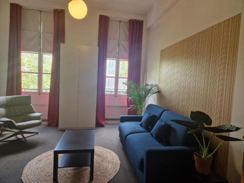 un salon avec un canapé bleu et une chaise dans l'établissement Le Circus, à Paris