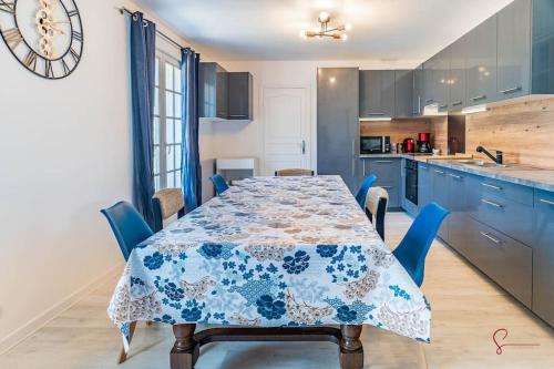 une cuisine avec une table et des armoires bleues dans l'établissement Villa Horizon à Carantec, à Carantec