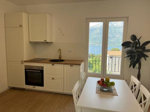 a kitchen with a table with a bowl of fruit on it at Apartments Laura in Korčula