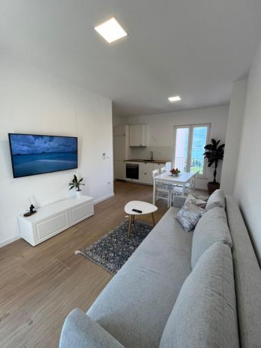 a living room with a gray couch and a kitchen at Apartments Laura in Korčula