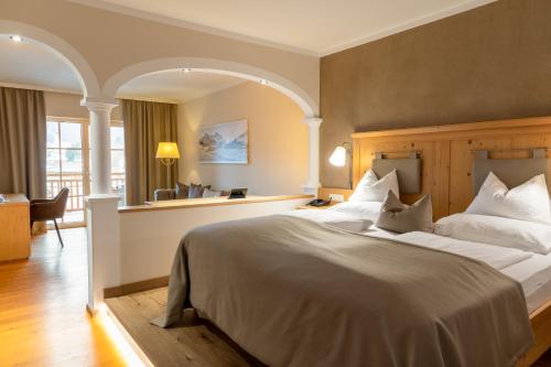 a bedroom with a large bed and a desk at POST Family Resort in Unken