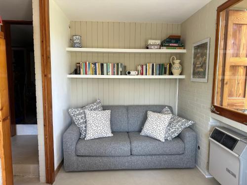 a gray couch with pillows in a living room at B&b Casa Rioletta in Bologna