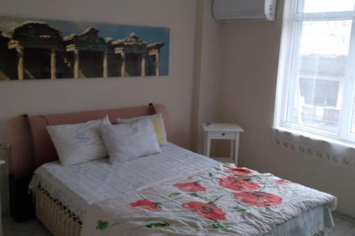 een slaapkamer met een bed met een bloemendeken erop bij MCKızılsaray Apart in Antalya