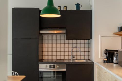 a kitchen with a black refrigerator and a sink at Disneyland 5 min -Paris 35 min -2/4 personnes in Montévrain