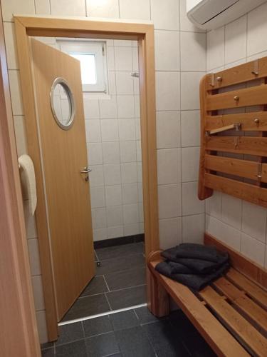 a bathroom with a shower with a wooden door at Auszeit 39 in Stadtoldendorf