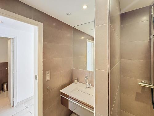 une salle de bain avec un lavabo et un miroir dans l'établissement 57m2 - 2 chambres, terrasse, Croisette-Martinez, à Cannes