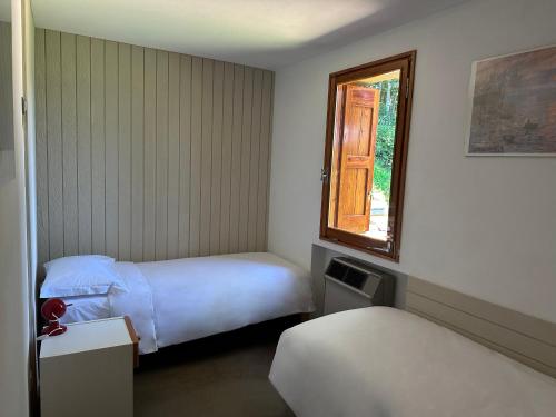 a hotel room with two beds and a window at B&b Casa Rioletta in Bologna