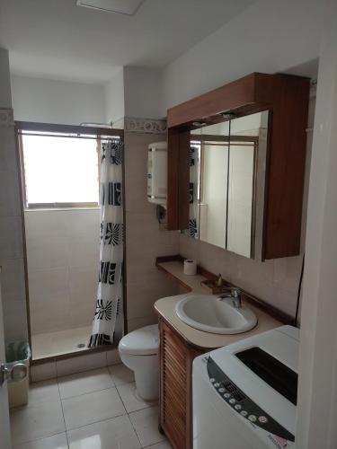 une salle de bain avec un lavabo, des toilettes et un miroir dans l'établissement Apartamento cerca del Boulevard de Sabana Grande y zona comercial, à Caracas