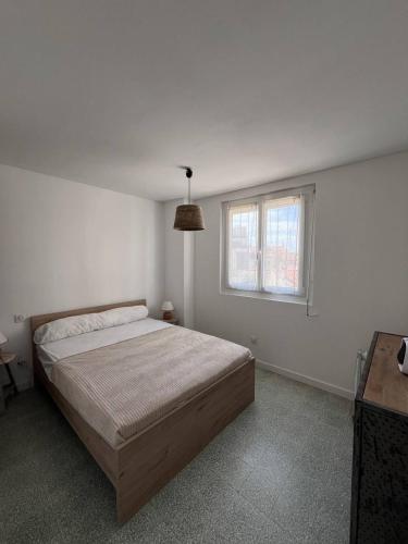 une chambre blanche avec un lit et une fenêtre dans l'établissement Appartement T2 à 50 M de la plage - 4CDUSUD8, à Canet