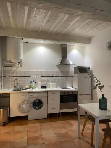 Il comprend une cuisine équipée d'une cuisinière, d'un évier et d'une table. dans l'établissement Studio du vieux port de la ciotat, à La Ciotat