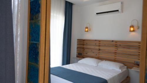 a bedroom with a bed with a wooden head board at Bük Butik Otel in Datca