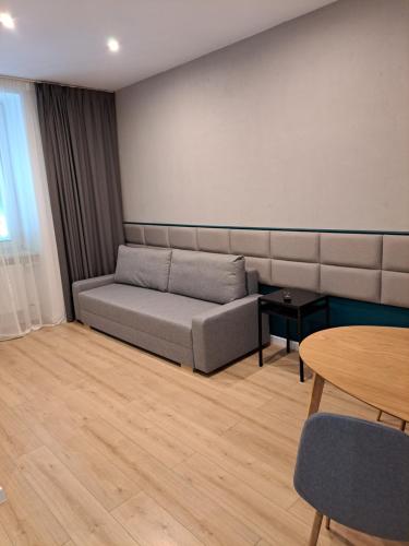 a living room with a couch and a table at BOOGIE Home Kamienica Łódzka in Łódź