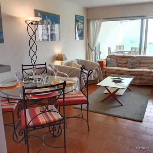 un salon avec une table et un canapé dans l'établissement Appartement T2 vue Mer, moderne classé 3 etoiles Parking 4ROSE326, à Canet