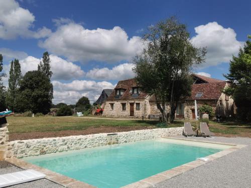 - une piscine en face d'une maison en pierre dans l'établissement Maison 6 pers Piscine Privée Plazac, à Plazac