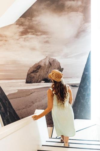 a woman walking down stairs at the beach at Stay Hotel Torres Vedras Centro in Torres Vedras