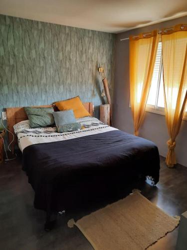 une chambre avec un grand lit dans une pièce dans l'établissement Villa avec piscine et cuisine d'été, à Sigean