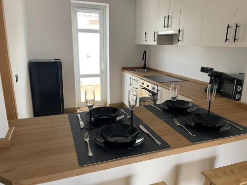 a kitchen with a table with plates and wine glasses at Calo's Place in Fisterra