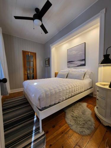 a bedroom with a bed and a ceiling fan at La Petite Maison in Rawdon